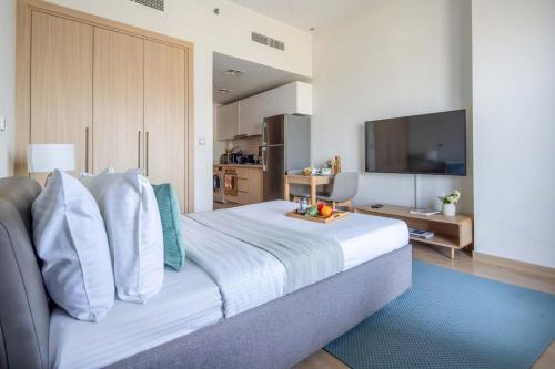 a bedroom with a large bed with a television at Frank Porter - Aura by Azizi in Dubai