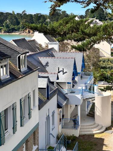a row of houses with blue balconies and the beach at Garrigae Cap Coz in Fouesnant