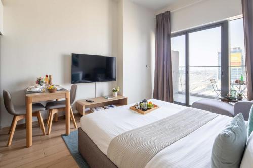 a hotel room with a large bed and a television at Frank Porter - Aura by Azizi in Dubai