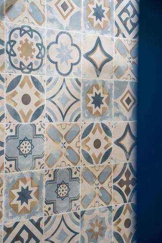 La salle de bains est pourvue de carrelage bleu et blanc. dans l'établissement Charmant T2 proche Place aux Herbes, à Uzès