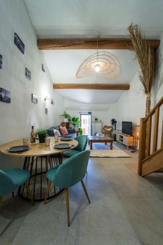 un salon avec une table et des chaises dans l'établissement Charmant T2 proche Place aux Herbes, à Uzès