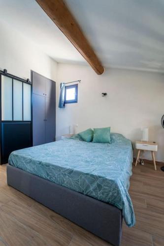 une chambre avec un lit avec une couette bleue dans l'établissement Charmant T2 proche Place aux Herbes, à Uzès