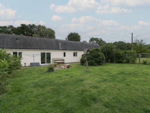 a white house with a large yard in front of it at The Turbles - Swallows Nest in Castlemorton