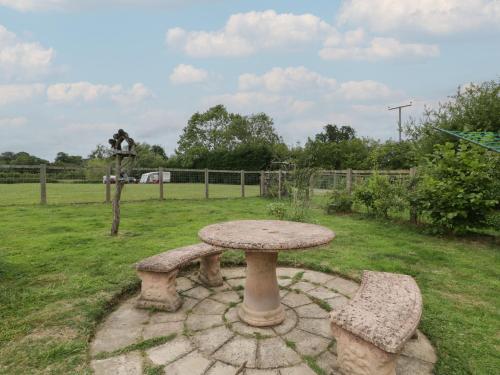 a stone table and two benches in a yard at The Turbles - Swallows Nest in Castlemorton