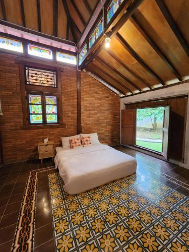 a bedroom with a large bed in a brick wall at Wulenpari EcoVillage in Sambipilu