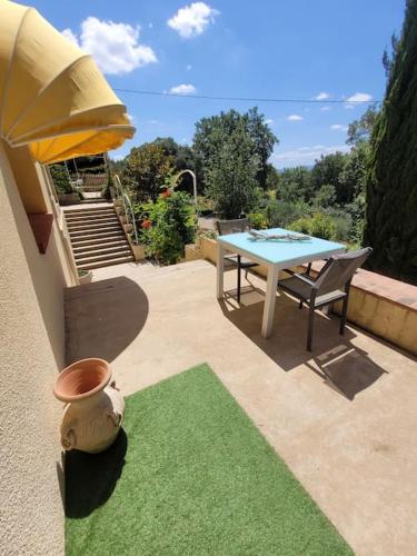 une terrasse avec une table et un tapis vert dans l'établissement Le Mas Les Salamandres, à Lorgues