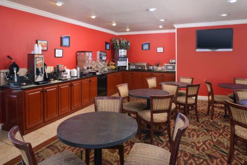 a restaurant with tables and chairs and red walls at Americas Best Value Inn Lubbock East in Lubbock