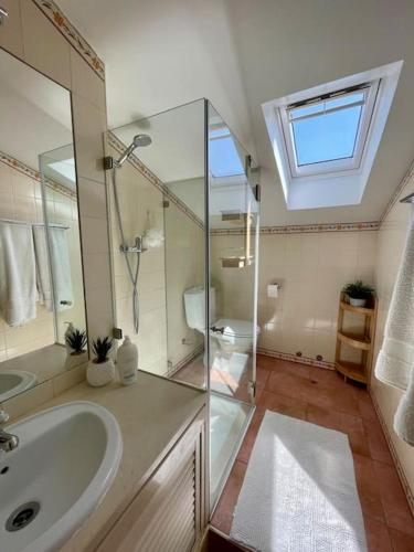 a bathroom with a sink and a shower at Caparica Golf & Beach Accomodation in Almada
