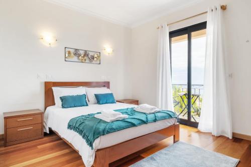 a bedroom with a bed and a large window at Atlantic Ocean Breeze in Ponta do Sol