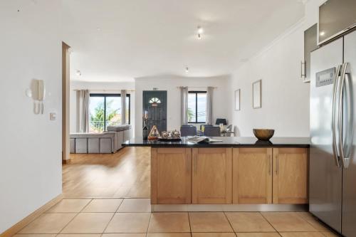 an open kitchen and living room with wooden cabinets at Atlantic Ocean Breeze in Ponta do Sol