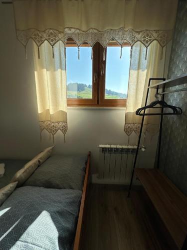 ein Schlafzimmer mit einem Bett und einem Fenster in der Unterkunft Pokoje Gościnne Bartuś in Czarna Góra
