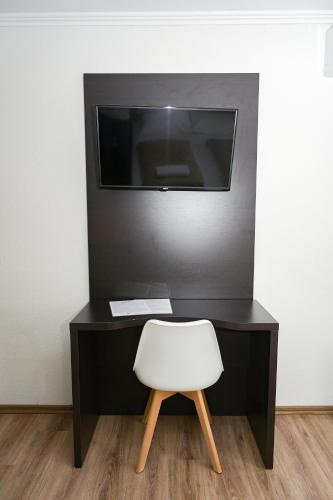 a desk with a white chair and a television at Motel Plaza in Jajce