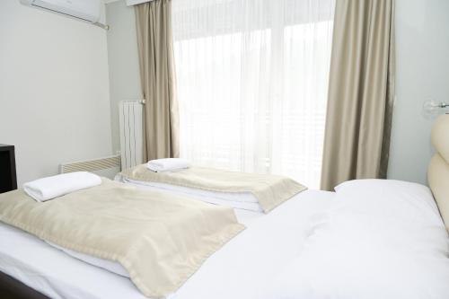two twin beds in a room with a window at Motel Plaza in Jajce