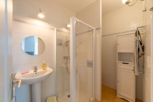 a white bathroom with a sink and a shower at Suisse Normande Refuge - Maison à la campagne 6p in Amayé-sur-Orne