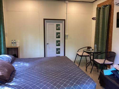 a bedroom with a bed and a table and chairs at Khlong sok camp in Ban Chieo Mon