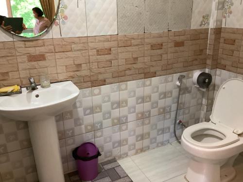 a bathroom with a toilet and a sink and a mirror at Khlong sok camp in Ban Chieo Mon