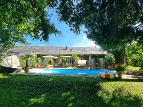 une maison avec une piscine dans la cour dans l'établissement Maison d'hôtes Les jardins Saint Eloi, à Le Lonzac