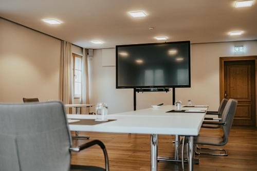 a conference room with a large screen on the wall at Landgasthof Jagstmühle in Heimhausen