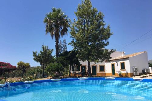 a swimming pool in front of a house at Quinta Rosa Branca in Tavira