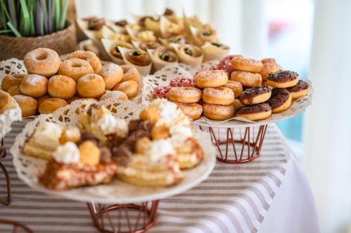 a table with two plates of donuts and other pastries at Hotel Orizzonte in Lido di Jesolo
