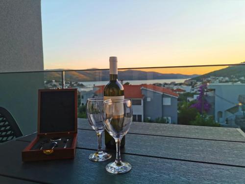 a bottle of wine and a wine glass on a table at Apartment Adriana in Seget Vranjica