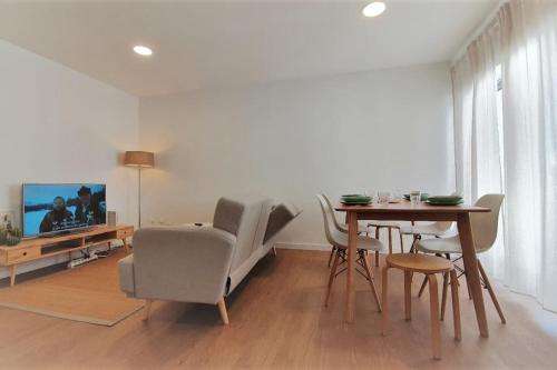 a living room with a table and chairs and a television at Apartment Marysol in Nazaré