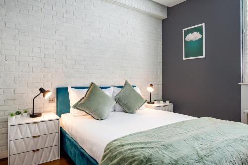 a bedroom with a large bed and a white brick wall at Welcome London - Drury Lane in London