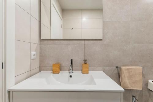 a white bathroom with a sink and a mirror at Apartment Marysol in Nazaré