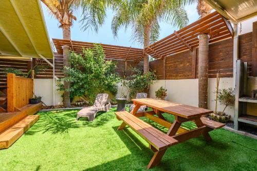 a picnic table and chairs in a backyard with palm trees at bali carmel zimmer & spa in Dāliyat el Karmil