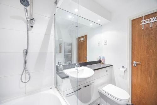 a bathroom with a shower and a sink and a toilet at Austin David Apartments ExCeL in London