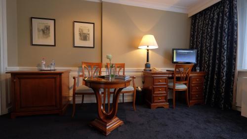 a hotel room with a desk with a computer and chairs at Apollofirst Boutique Hotel in Amsterdam