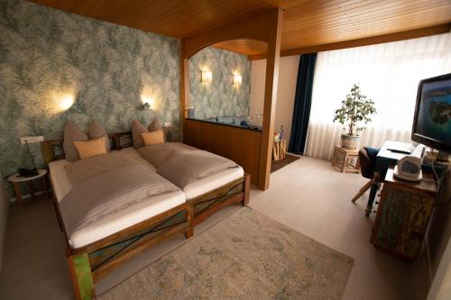 a bedroom with a bed and a desk and a television at Haus Rose in Allensbach
