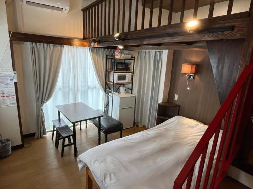 a bedroom with a bed and a desk and a table at Cozy inn Oyama in Tokyo