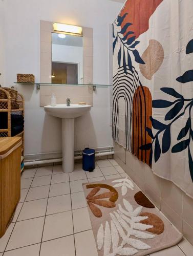 une salle de bain avec un lavabo et un miroir dans l'établissement Coco's, à Alfortville