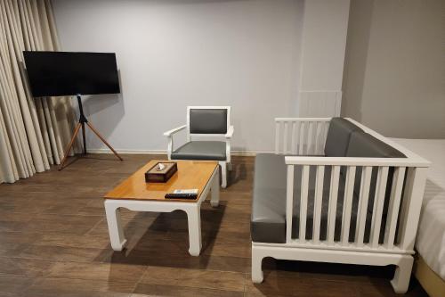 a living room with a couch and a coffee table at J PLACE HOTEL in Bangkok