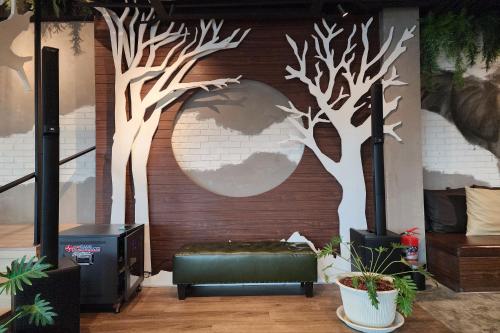 a room with a wall with a mural of trees at J PLACE HOTEL in Bangkok