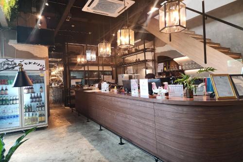 a restaurant with a large wooden bar in a room at J PLACE HOTEL in Bangkok