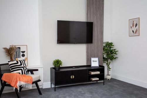a living room with a tv on a white wall at Vacant Nests Beamish Cottage Museum - WIFI in Beamish