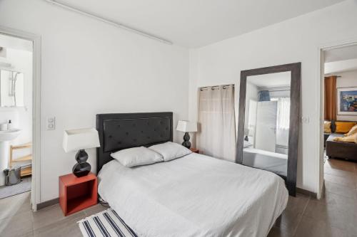 une chambre avec un grand lit et un miroir dans l'établissement Magnifique Appart Spacieux Versailles 4Pers, à Buc