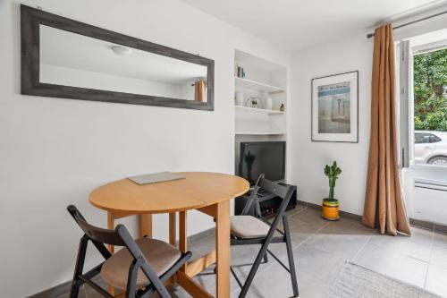 une salle à manger avec une table, des chaises et un miroir dans l'établissement Magnifique Appart Spacieux Versailles 4Pers, à Buc