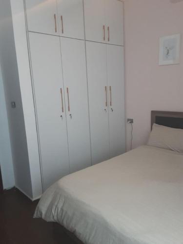 a bedroom with white cabinets and a white bed at Casa Feliz - Stylish 2 Bedroom Apartment in Addis Ababa