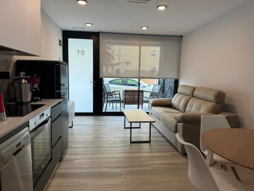 een keuken en woonkamer met een bank en een tafel bij Apartamentos Turísticos Vidal Costa in Foz