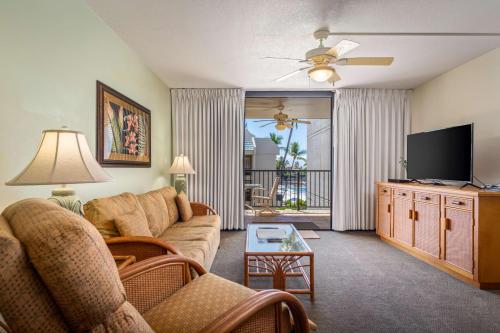 a living room with a couch and a flat screen tv at Aston Kona By The Sea in Kailua-Kona