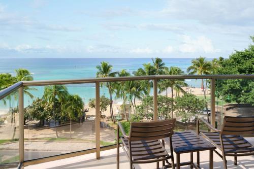 a balcony with chairs and a view of the beach at Aston Waikiki Circle Hotel in Honolulu