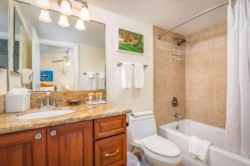 a bathroom with a sink and a toilet and a shower at Aston Kona By The Sea in Kailua-Kona