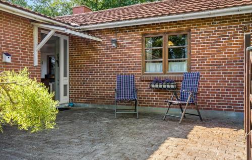 two blue chairs sitting outside of a brick house at Gorgeous Home In Jerup With Wifi in Jerup