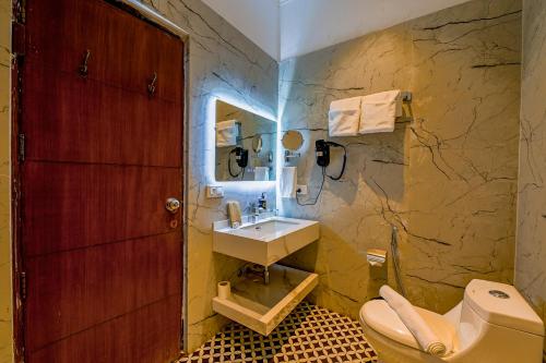 un bagno con lavandino e WC di WelcomHeritage Tarangi Ramganga Resort a Marchula