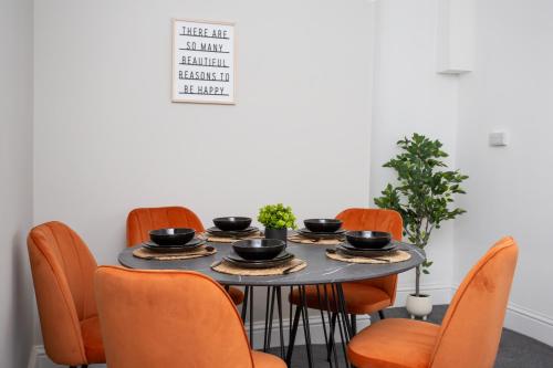 a dining room table with orange chairs around it at Vacant Nests Beamish Cottage Museum - WIFI in Beamish