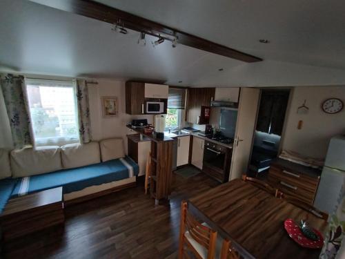 un salon avec un canapé et une cuisine dans l'établissement Mobil home l'oliverie, à Valras-Plage