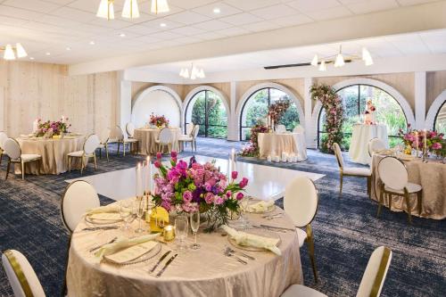 a banquet hall with tables and chairs with flowers at The Leta Santa Barbara Goleta, Tapestry Collection by Hilton in Santa Barbara